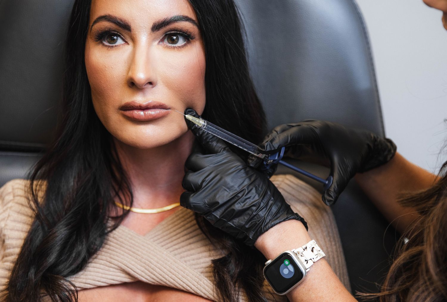 Woman receiving cosmetic treatment with syringe.