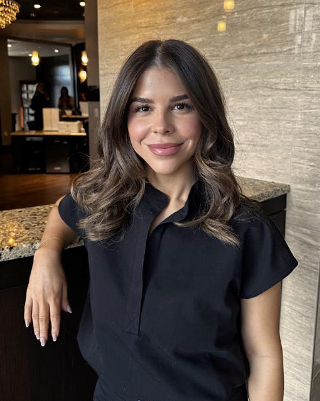 Smiling woman in a stylish black outfit.