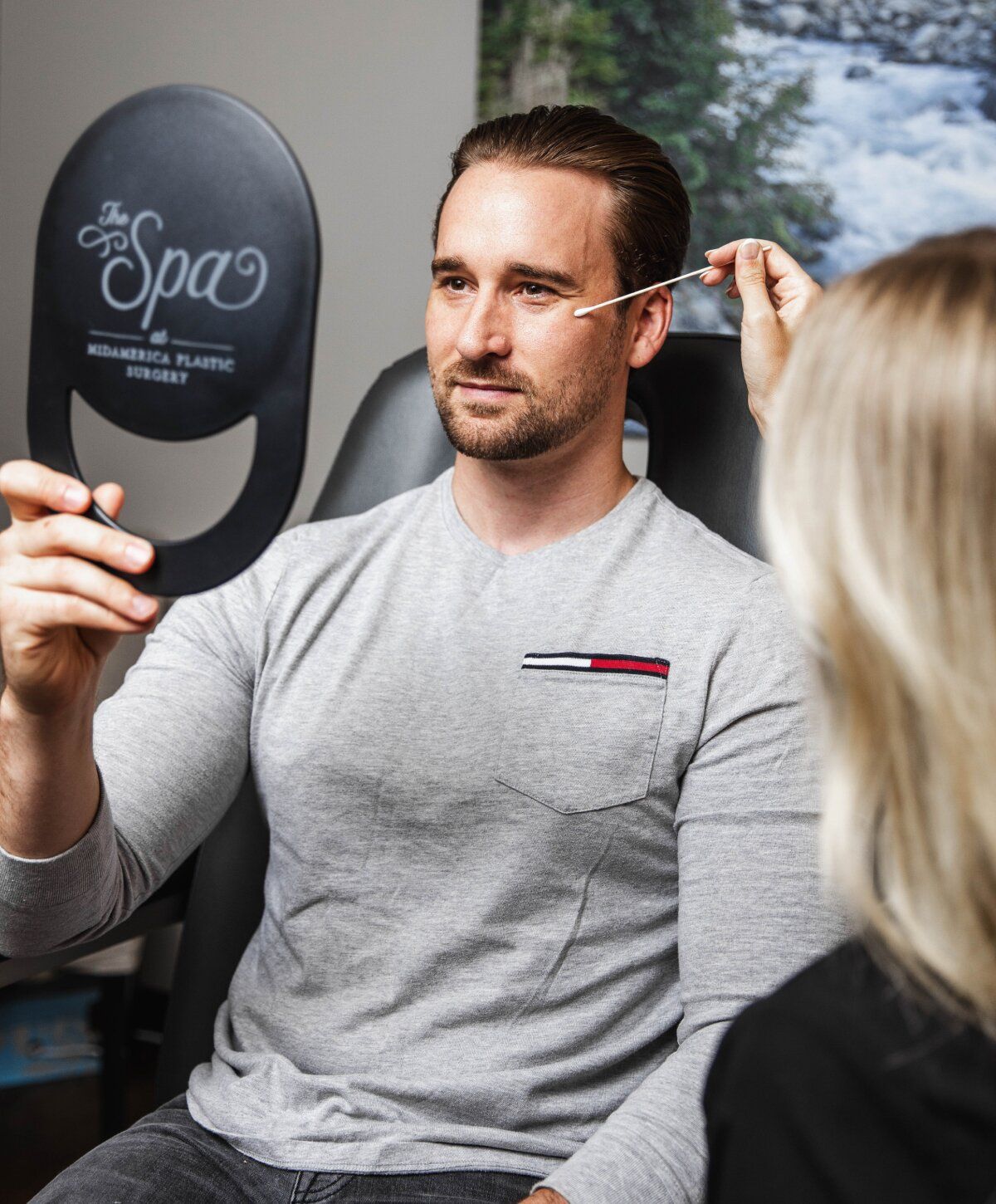 Man examining himself during a cosmetic procedure.