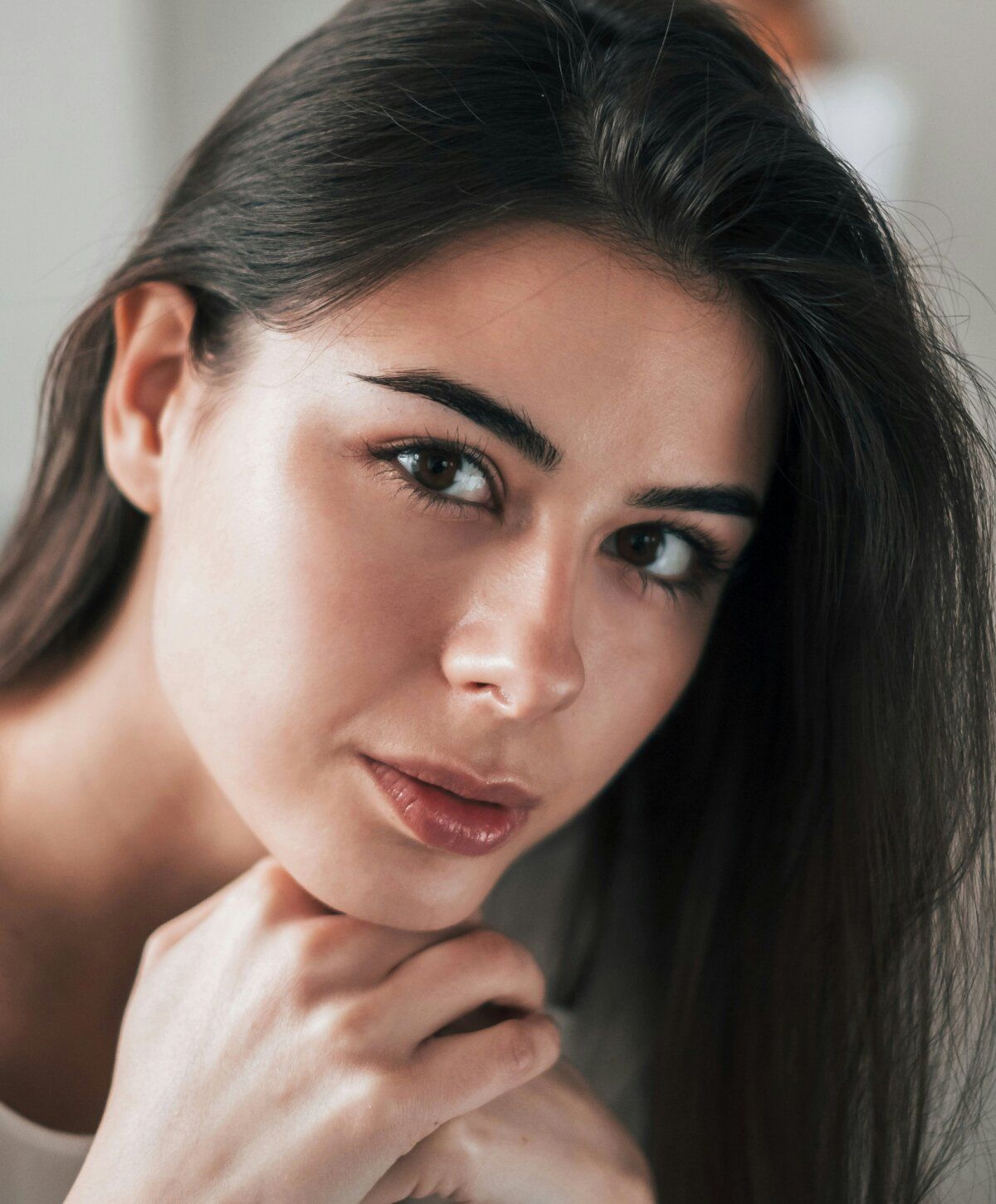 Young woman resting chin on hand.