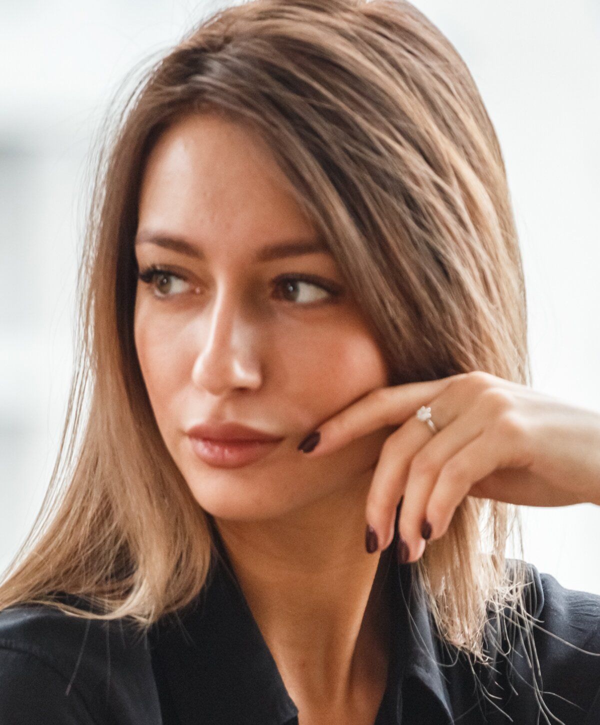 Thoughtful woman with a ring on her finger.
