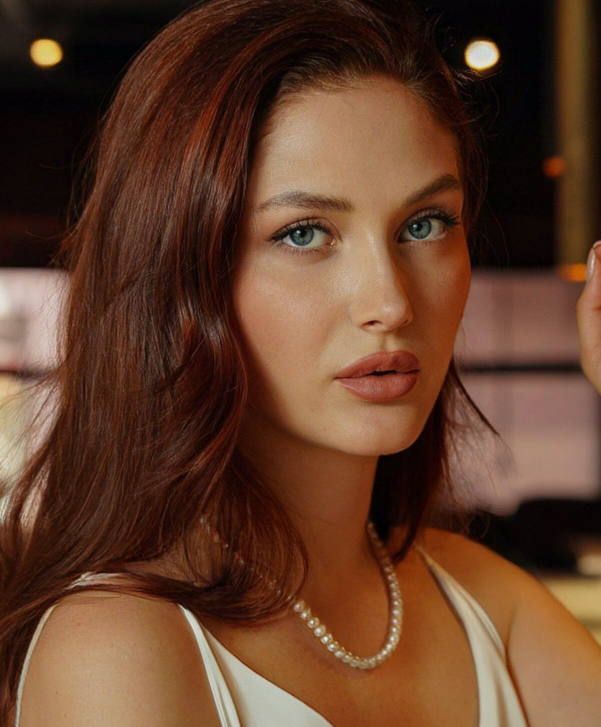 Woman with blue eyes and brown shoulder-length hair.