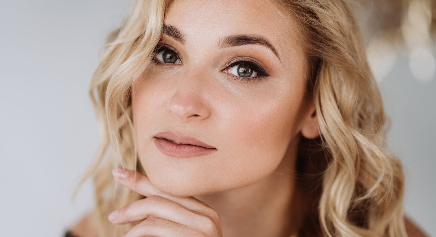 Close-up of a woman with blonde, wavy hair.